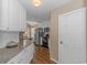 Well-lit kitchen with white cabinetry, stainless steel appliances, and hardwood floors at 2454 Glen Dr., Little River, SC 29566
