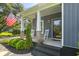 Close-up of the charming front porch featuring rocking chairs and an American flag at 2588 Long Avenue Ext., Conway, SC 29526