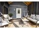 Covered patio with television, neutral colored furniture and shade providing curtains at 2588 Long Avenue Ext., Conway, SC 29526