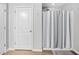 Bathroom showcasing a shower-tub combo with striped shower curtain and a white panel door at 317 Truce St., Myrtle Beach, SC 29588