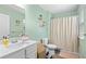 Light and airy bathroom featuring mint walls, a white vanity, and a shower-tub combo at 317 Truce St., Myrtle Beach, SC 29588
