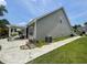 Exterior view of the home's side, featuring a paved patio, pergola, and well-kept lawn at 340 Barony Dr., Conway, SC 29526