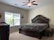 This main bedroom features a ceiling fan, large window, and dark wood furniture with ornamental details at 340 Barony Dr., Conway, SC 29526