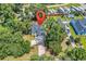 Aerial view of a landscaped property with a blueish-grey house, long driveway, and mature trees at 3864 Journeys End Rd., Murrells Inlet, SC 29576