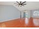 An expansive living room featuring wood floors, vaulted ceiling with fan, and large windows for natural light at 3888 Stillwood Dr., Myrtle Beach, SC 29588