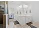 Bathroom featuring double sinks, white cabinetry, and tiled floors with a view to the primary bedroom at 405 Spring View Ct., Little River, SC 29566