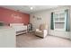 Adorable Bedroom with a pink accent wall, white crib, and cozy seating area near a window at 405 Spring View Ct., Little River, SC 29566