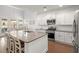 Bright kitchen with white cabinets, stainless steel appliances, and a large island with a sink at 405 Spring View Ct., Little River, SC 29566