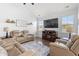 Cozy living room with comfortable seating, a fireplace, and a large screen television with lots of natural light at 405 Spring View Ct., Little River, SC 29566