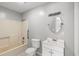 Bathroom featuring a tub/shower combination and a white vanity with sink and a round mirror at 4249 E Highway 9, Loris, SC 29569