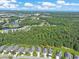 Areal view of a quiet residential neighborhood with a pond, dense trees, and the ocean in the distance at 428 Arlington Circle, Murrells Inlet, SC 29576