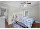 This cozy bedroom boasts a ceiling fan, wood floors, and a comfortable-looking bed with blue and white striped bedding at 4325 Ellis Ave., Little River, SC 29566