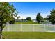 View of the community backyard with a pond, green grass, white fence, and blue skies at 445 Mooreland Dr., Myrtle Beach, SC 29588