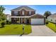 Two-story brick home with a manicured lawn, showcasing its charming front facade and attached garage at 445 Mooreland Dr., Myrtle Beach, SC 29588