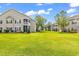 Exterior view showcasing lush green lawn, community residences, and screened in porches at 447 Mahogany Dr. # 102, Murrells Inlet, SC 29576