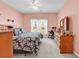 Bedroom with a floral comforter, rocking chair, and soft pink walls at 447 Mahogany Dr. # 102, Murrells Inlet, SC 29576