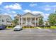 Inviting condo with covered front porch and white railings, landscaping, and ample parking at 447 Mahogany Dr. # 102, Murrells Inlet, SC 29576