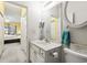 This bathroom features a white sink, vanity, round mirror, and toilet with a view into the adjacent bedroom at 4518 N Plantation Dr. # G-5, Little River, SC 29566