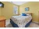 Bright bedroom featuring a queen-sized bed, wooden dresser, and bright yellow walls at 4518 N Plantation Dr. # G-5, Little River, SC 29566