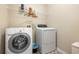 Well-lit laundry room featuring a washer and dryer and shelving for storage of laundry supplies at 468 Papyrus Circle # 468, Little River, SC 29566