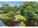 Aerial view of a serene backyard with a wooden dock and fire pit, nestled amidst lush trees at 485 Waterford Dr., Georgetown, SC 29440