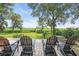 Relaxing backyard view from the wooden deck with Adirondack chairs overlooking the expansive lawn at 485 Waterford Dr., Georgetown, SC 29440