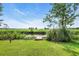 Scenic backyard view of a wooden dock extending into a peaceful canal, surrounded by lush greenery at 485 Waterford Dr., Georgetown, SC 29440