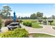 Exterior shot of picnic table, BBQ, and pond in a serene, wooded area at 4872 Dahlia Ct. # 305, Myrtle Beach, SC 29577