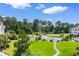 View of community pool with lounge chairs surrounded by lush landscaping on a sunny day at 4872 Dahlia Ct. # 305, Myrtle Beach, SC 29577