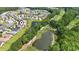 Aerial view of a neighborhood with ponds, a golf course, and mature trees at 492 Grand Cypress Way, Murrells Inlet, SC 29576