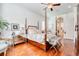 A light-filled main bedroom with hardwood floors has stylish furniture and tasteful decor at 492 Grand Cypress Way, Murrells Inlet, SC 29576