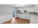 Efficient kitchen featuring white cabinets, stone backsplash, and durable wood-look flooring at 5 Dogwood St., Hemingway, SC 29554