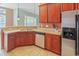 Bright kitchen featuring stainless steel appliances, tile flooring, breakfast bar and dark wood cabinets at 56 Willowbend Dr., Murrells Inlet, SC 29576