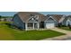 Charming blue home showcasing a covered porch, well-maintained lawn, and attached two-car garage at 567 Hickman St., Myrtle Beach, SC 29575