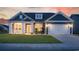 Charming single-story home with a covered front porch, lush lawn, and attached two-car garage at sunset at 567 Hickman St., Myrtle Beach, SC 29575