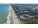 Expansive aerial view showcases a stunning coastal community with oceanfront resorts, sandy beaches, and lush green spaces at 5826 Cremona Dr., Myrtle Beach, SC 29577
