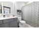 A well-lit bathroom with a modern vanity, toilet, and shower with patterned curtain at 5826 Cremona Dr., Myrtle Beach, SC 29577