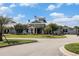 Clubhouse exterior with a well-manicured lawn, mature trees, and American and community flags waving in the breeze at 5826 Cremona Dr., Myrtle Beach, SC 29577