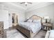 Spacious main bedroom with large bed, tray ceiling, and well-lit view to an en-suite bathroom at 5826 Cremona Dr., Myrtle Beach, SC 29577