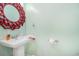 Cozy powder room features pedestal sink and charming red-framed mirror at 6001-R11 S Kings Hwy., Myrtle Beach, SC 29575