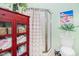 This bathroom features a shower stall with a striped curtain, along with red cabinet and a toilet at 6001-R11 S Kings Hwy., Myrtle Beach, SC 29575