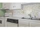 Cozy kitchen featuring white cabinets, mosaic tile backsplash, and modern appliances at 601 Mitchell Dr. # 607, Myrtle Beach, SC 29577