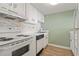Well-lit kitchen featuring white appliances and cabinets, mosaic backsplash, and ample counter space at 601 Mitchell Dr. # 607, Myrtle Beach, SC 29577
