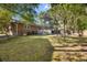 Spacious backyard featuring a well-maintained lawn, mature trees, patio furniture, and a charming brick home exterior at 6210 Blynn Dr., Myrtle Beach, SC 29572