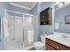 Bathroom with glass shower doors, dark wood vanity, blue walls, and chrome hardware at 6253 Catalina Dr. # 1824, North Myrtle Beach, SC 29582