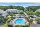 Aerial view of a sparkling community pool with lounge chairs and palm trees surrounded by lush greenery at 6253 Catalina Dr. # 1824, North Myrtle Beach, SC 29582