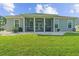 Expansive backyard with a screened patio, lush lawn, and manicured landscaping at 668 Barona Dr., Myrtle Beach, SC 29579