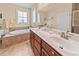 Bright bathroom featuring double sinks, large mirror, a soaking tub, and a window providing natural light at 668 Barona Dr., Myrtle Beach, SC 29579