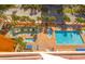 A pool area with a lazy river and a pool with lounge chairs in front of an orange high-rise condominium building at 6900 N Ocean Blvd. # 734, Myrtle Beach, SC 29572