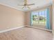 Bright bedroom with neutral walls, wood-look floors, ceiling fan, and large window with backyard view at 708 Alexis Dr., Longs, SC 29568